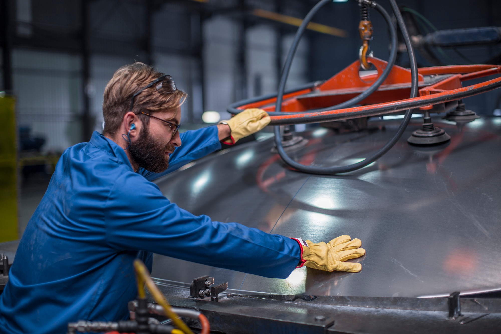 Worker in steel factory inspecting a tank